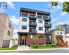 A modern apartment building with a balcony on the second floor.
