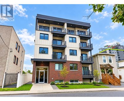 A modern apartment building with a balcony on the second floor.