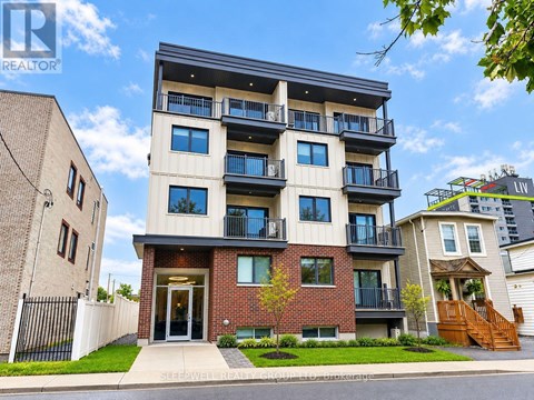 A modern apartment building with a balcony on the second floor.