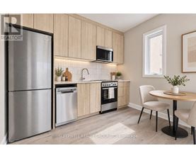 A modern kitchen with a refrigerator, microwave, oven, and sink.