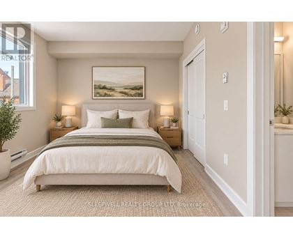 A well-lit bedroom with a large bed and a painting on the wall.