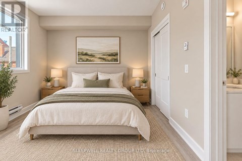 A well-lit bedroom with a large bed and a painting on the wall.