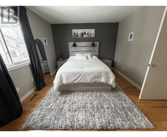 A bedroom with a large bed and a grey rug.