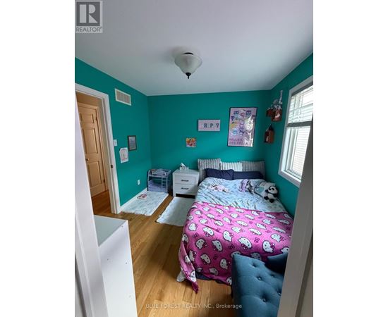 A bedroom with a bed, dresser, and window.