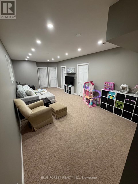 A living room with a grey carpet and a white sofa.