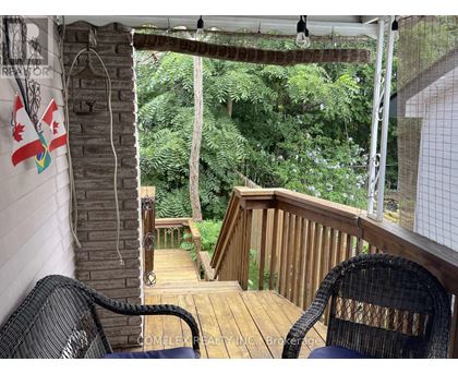 A balcony with a chair and a view of the trees.