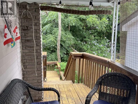 A balcony with a chair and a view of the trees.