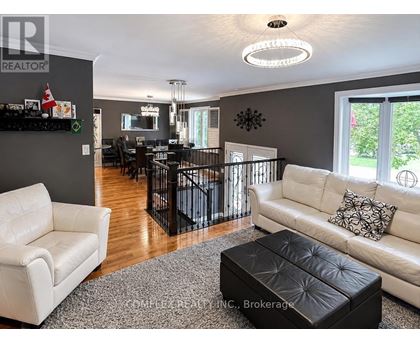 A living room with a white couch and a black ottoman.