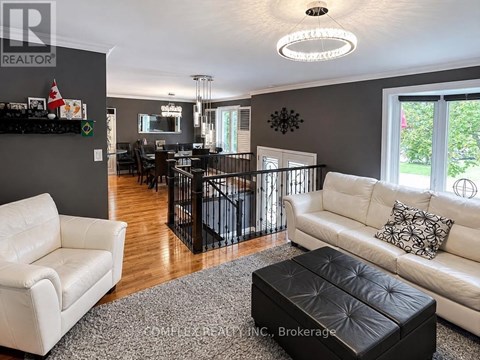 A living room with a white couch and a black ottoman.