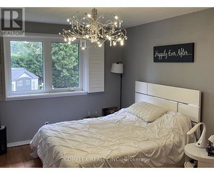 A bedroom with a white bed and a chandelier.