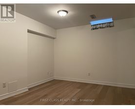 A room with wooden flooring and white walls.
