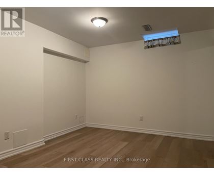 A room with wooden flooring and white walls.