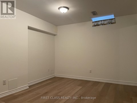 A room with wooden flooring and white walls.