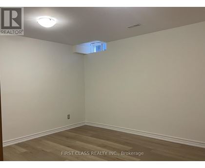 A room with a wooden floor and a light on the ceiling.