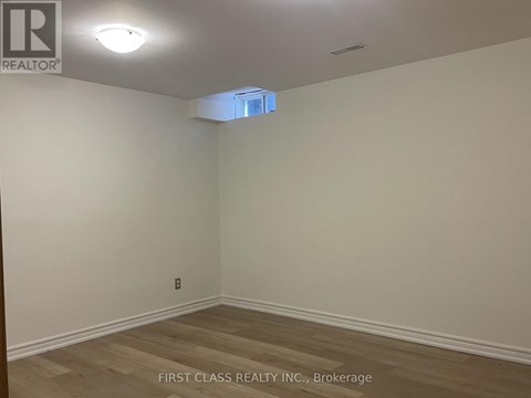 A room with a wooden floor and a light on the ceiling.