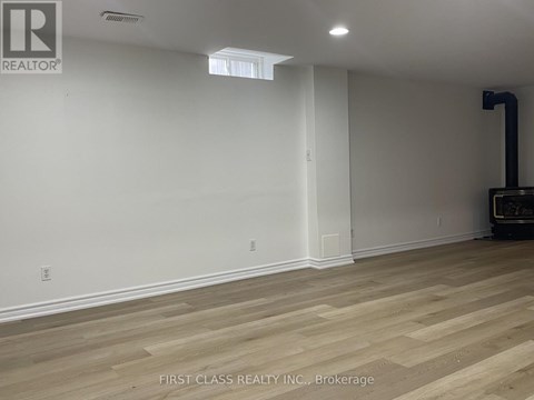 A room with wooden flooring and a white wall.
