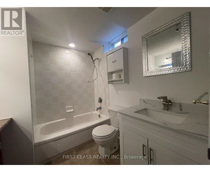 A white bathroom with a toilet, sink, and bathtub.