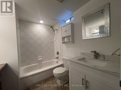 A white bathroom with a toilet, sink, and bathtub.