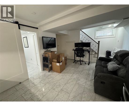 A living room with a couch, chair, and a television.