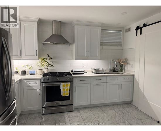 A kitchen with a stove top oven and a sink.