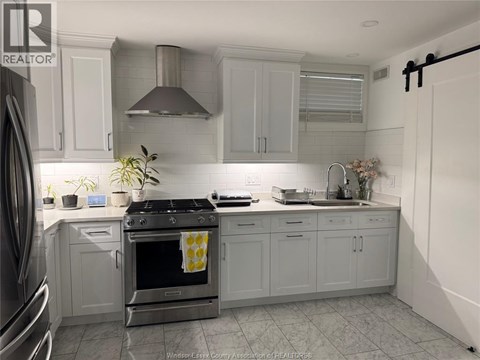A kitchen with a stove top oven and a sink.