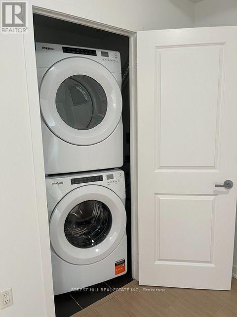 A white door is open to a small laundry room with a washer and dryer.