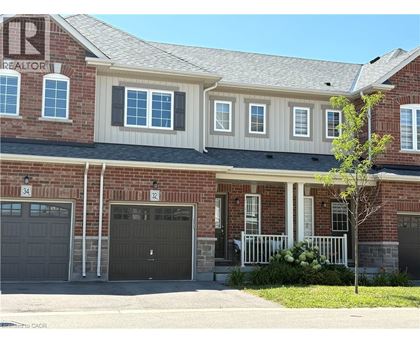 A house with a garage and a tree in front.