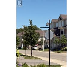 A street view with a stop sign and a house in the background.
