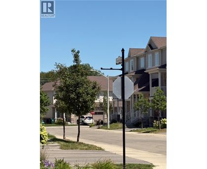 A street view with a stop sign and a house in the background.
