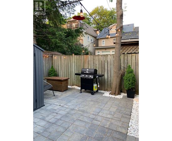 A BBQ grill is on a patio with a table and chairs.
