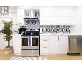 A modern kitchen with a stainless steel refrigerator and a white oven.