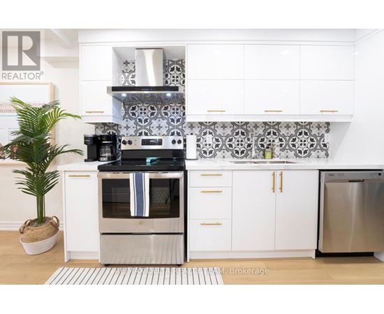 A modern kitchen with a stainless steel refrigerator and a white oven.
