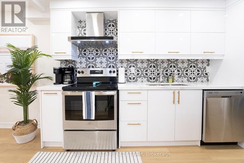 A modern kitchen with a stainless steel refrigerator and a white oven.