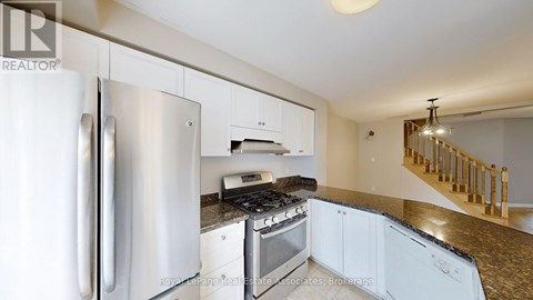 A kitchen with a stainless steel refrigerator and a stove top oven.