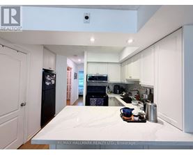 A kitchen with white cabinets and a marble countertop.