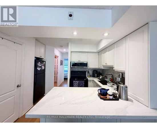 A kitchen with white cabinets and a marble countertop.