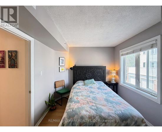 A bedroom with a bed, chair, and lamp.