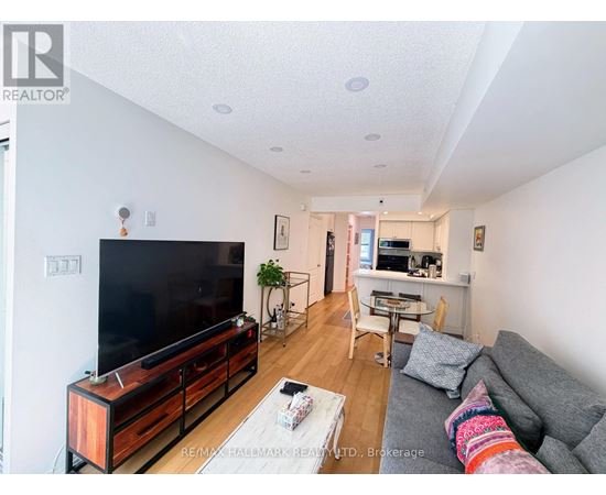 A living room with a grey couch and a wooden entertainment center.