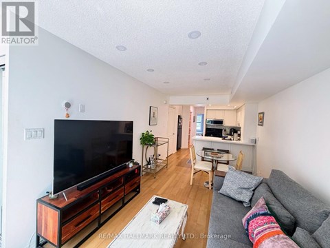 A living room with a grey couch and a wooden entertainment center.