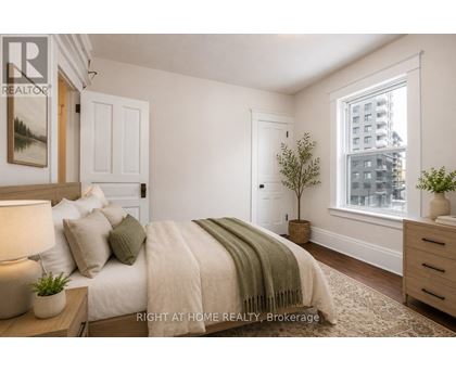 A bedroom with a bed, nightstand, and window.