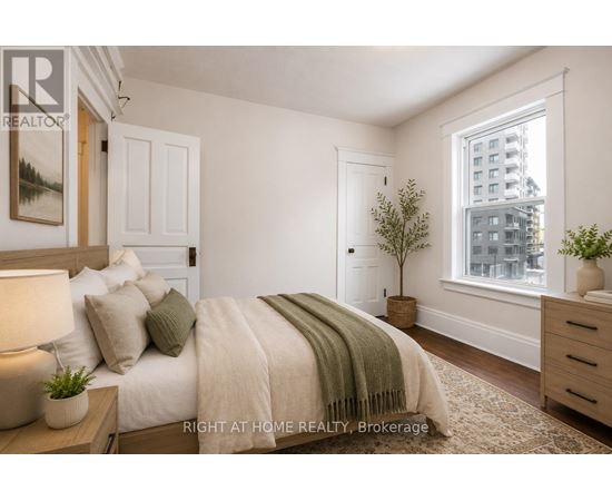 A bedroom with a bed, nightstand, and window.