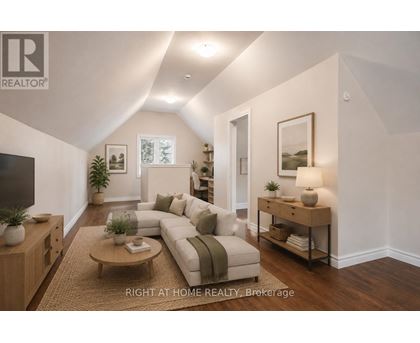 A well-lit living room with a couch, coffee table, and a television.