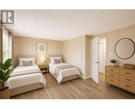A bedroom with two beds, a dresser, and a mirror.