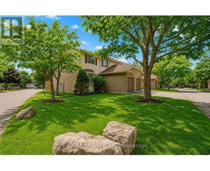 A house with a lawn and trees in front of it.