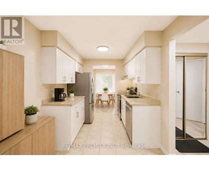 A modern kitchen with white cabinets and a wooden island.