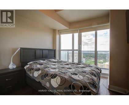 A bedroom with a large bed and a view of the city.