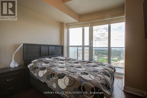 A bedroom with a large bed and a view of the city.