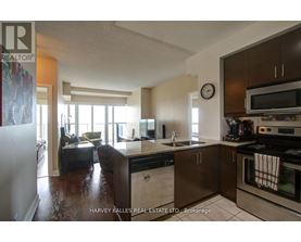 A kitchen with a refrigerator, sink, and oven.