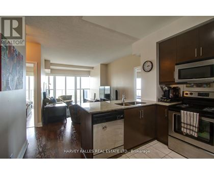A kitchen with a refrigerator, sink, and oven.