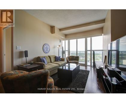 A living room with a couch, chair, and television.